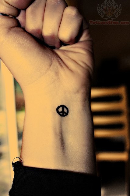 Tiny Peace Sign Tattoo On Left Wrist
