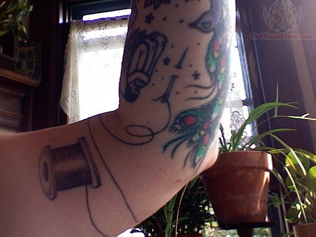 Spool And Needle Tattoo On Bicep