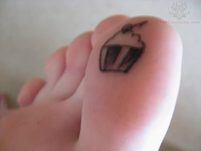 Grey Ink Cupcake Tattoo On Bottom Of Toe