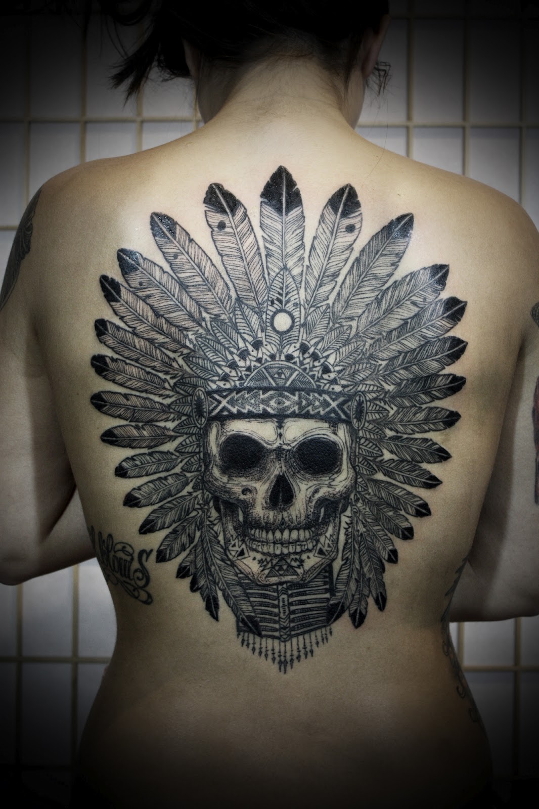 Skull With Hawk Feathers Grey Ink Tattoo On Back