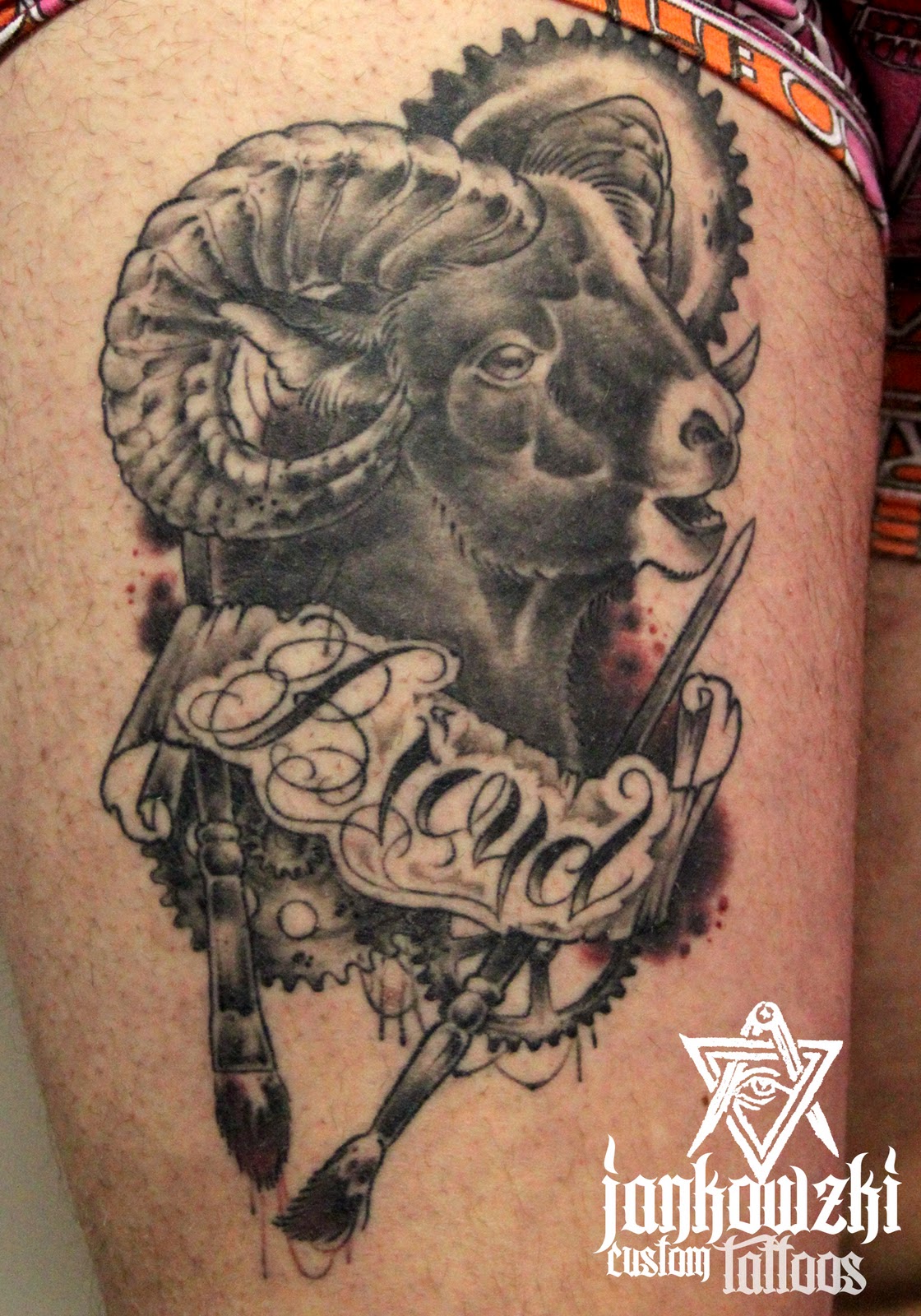 Grey Ink Banner And Aries Head Tattoo