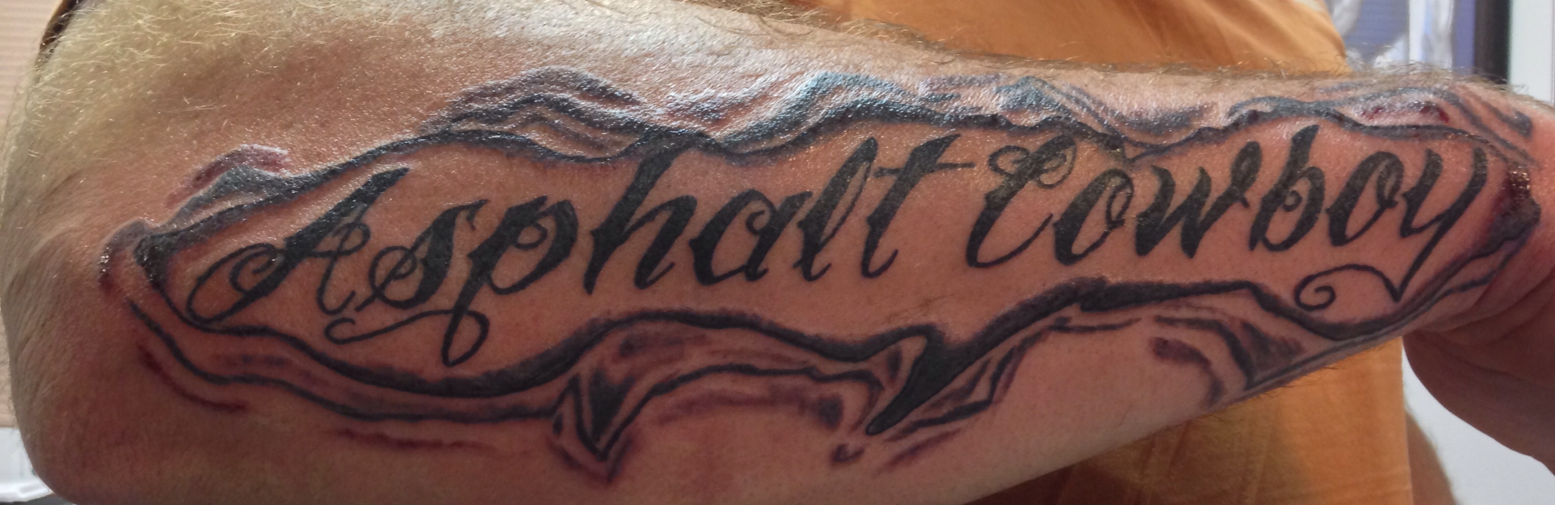 Asphalt Cowboy – Lettering Tattoo On Right Arm