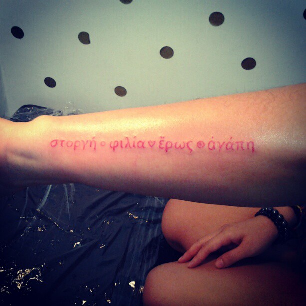 Red Ink Greek Tattoo On Sleeve