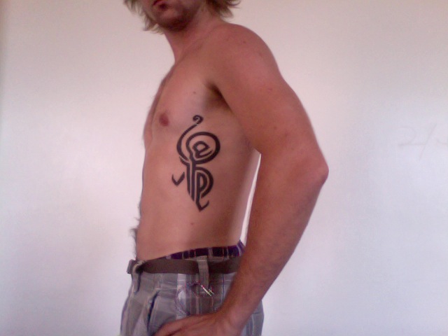 Black Tribal Hakuna Matata Tattoo On Man Left Side Rib