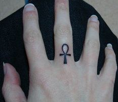 Small Black Ankh Tattoo On Middle Finger