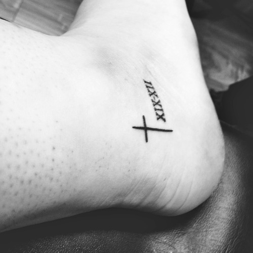Small Black Cross Christian Tattoo On Heel