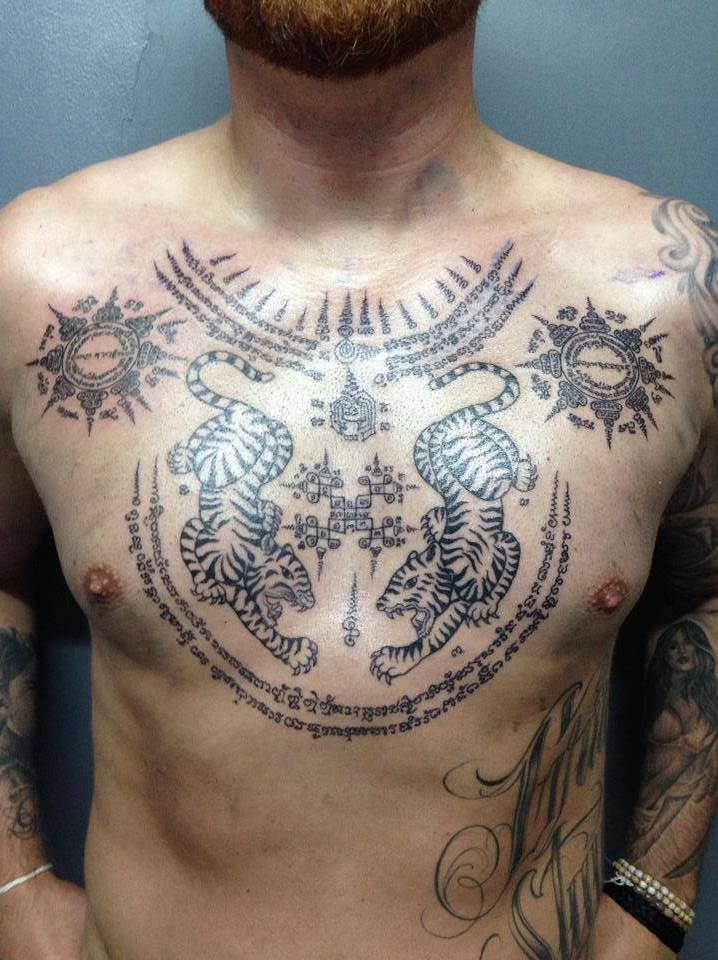 Grey Ink Traditional Thai Tattoo On Man Chest