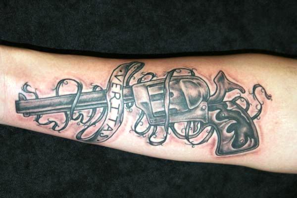 Pistol Tattoo With Veritas Banner On Arm