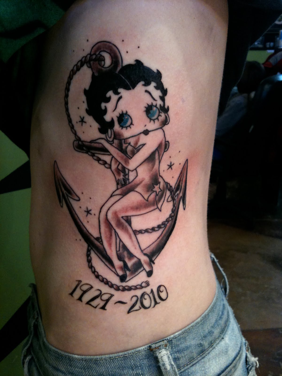Betty Boop Sitting On Anchor Memorable Tattoo On Rib Cage