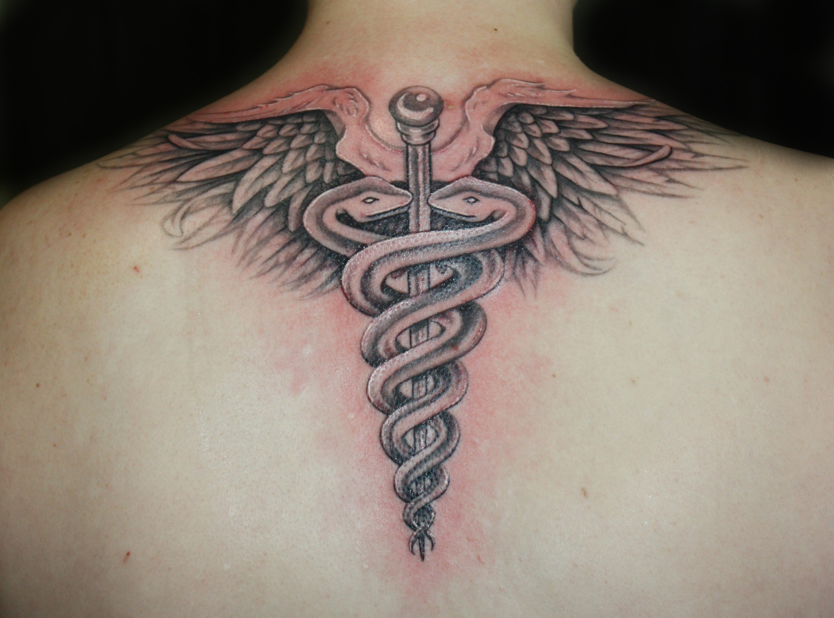 Medical Symbol Tattoo On Upper Back
