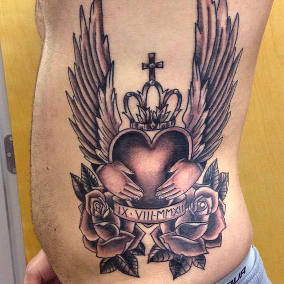 Grey Rose Flowers And Claddagh Tattoo On Man Side Rib