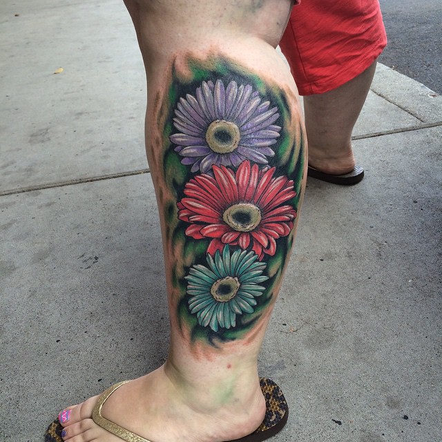 Colored Daisy Tattoos On Left Leg