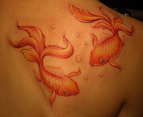 Orange Ink Fish Tattoo On Right Back Shoulder